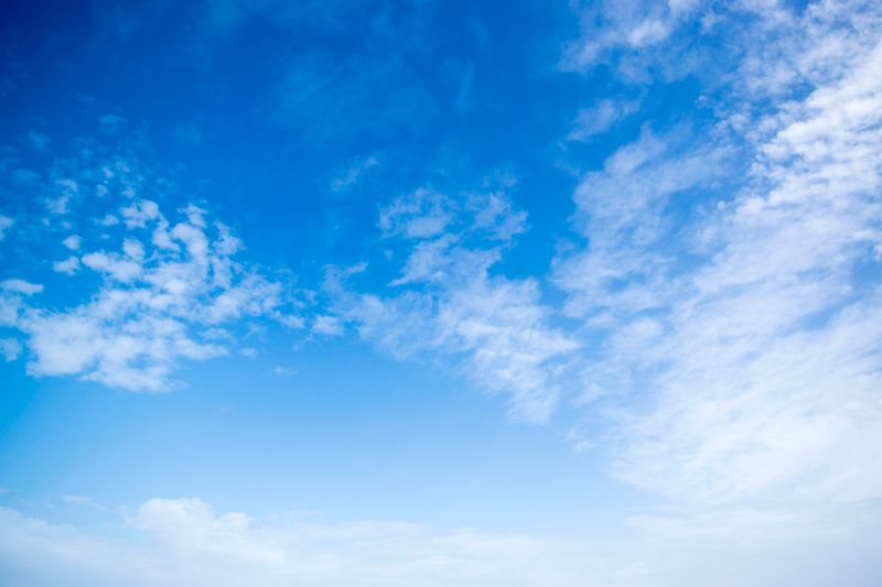 A clear bright blue sky with fluffy white clouds